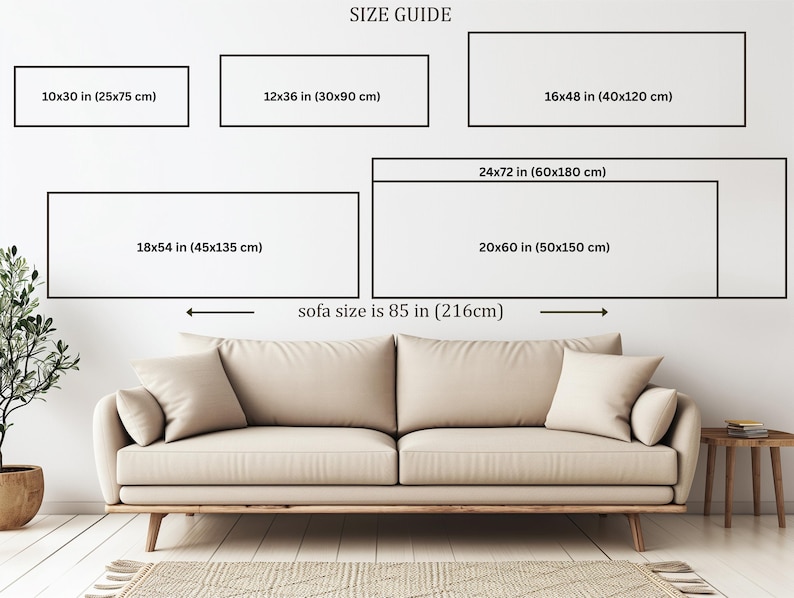 a living room with a large beige sofa, a wooden side table, and a potted plant. The sofa is positioned in front of a wall with a size guide for artwork, providing dimensions for different sizes of framed artworks.
