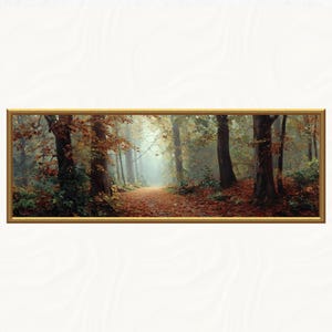 Könnte beinhalten: Gerahmtes Landschaftsgemälde eines Waldweges im Herbst. Der Weg ist mit Herbstlaub bedeckt und führt in eine neblige, sonnenbeschienene Lichtung. Die Bäume haben braune und orangefarbene Blätter, und der Rahmen ist goldfarben.