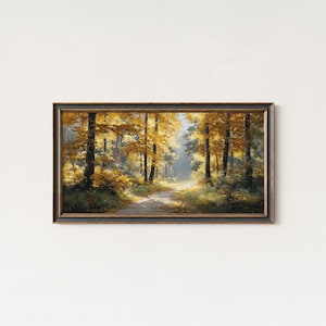 Può includere: Dipinto paesaggistico incorniciato di una scena di foresta illuminata dal sole. L'opera presenta un sentiero che si snoda tra alberi con foglie dorate, evocando un'atmosfera autunnale. Il dipinto è racchiuso in una cornice di legno scuro.