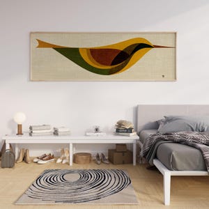 Op de afbeelding: Een rechthoekig, ingelijst kunstwerk met een gestileerd vogelontwerp. De vogel is afgebeeld in tinten geel, groen, bruin en zwart tegen een neutrale achtergrond. Het kunstwerk is ingelijst in licht hout.