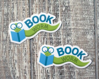 May include: Two green bookworm stickers with blue books and the text "BOOK WORM" on a white wood background.