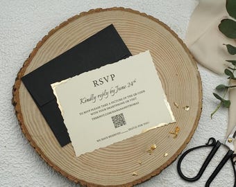 Op de afbeelding: Een RSVP-kaart met gouden rand en een zwarte envelop op een houten schijf. De kaart leest "RSVP Kindly reply by June 24" en bevat een QR-code en website. Gouden bladeren accentueren de scène, wat duidt op een bruiloftsthema.