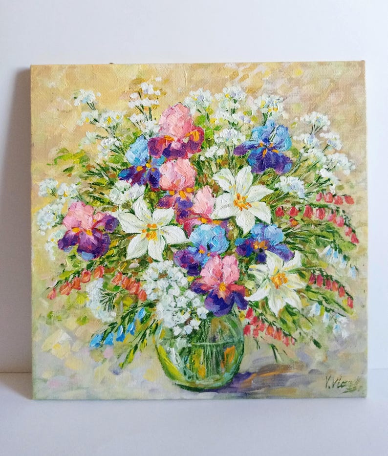 May include: Oil painting of a vibrant floral arrangement in a clear glass vase. The bouquet features irises in shades of pink, purple, and blue, along with white lilies and delicate white blossoms. The background is a soft, textured yellow.