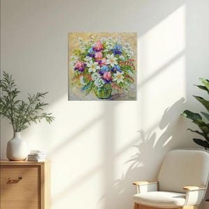 May include: An oil painting of a vibrant floral arrangement in a green glass vase. The bouquet features white, pink, purple, and blue flowers. The artwork is displayed on a beige wall, with a wooden cabinet and chair in the foreground.