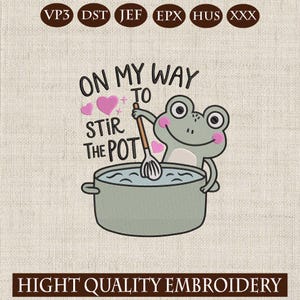 Op de afbeelding: Een geborduurd ontwerp met een cartoonkikker die in een pot roert. De tekst luidt "ON MY WAY TO STIR THE POT" met roze hartjes. Het ontwerp staat op een lichtbeige stof, met de woorden "HIGH QUALITY EMBROIDERY" onderaan.