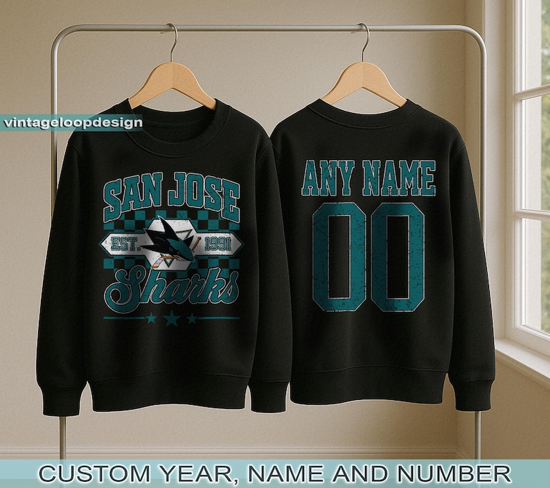 May include: Black sweatshirt featuring a "SAN JOSE Sharks" logo on the front and "ANY NAME" and number on the back. The logo includes a shark fin and the text "EST. 1991". The bottom of the image reads "CUSTOM YEAR, NAME AND NUMBER".
