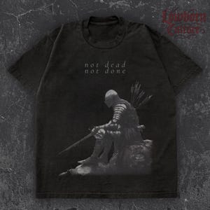 Maglietta &quot;Not Dead Not Done&quot; - Maglietta con spada da cavaliere caduto - Maglietta fantasy dark da guerriero medievale - Design da battaglia con armatura da eroe resiliente