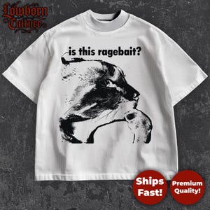 May include: White t-shirt with a black graphic of a panther and the text "is this ragebait?" The shirt has a crew neck and short sleeves. The Lowborn Culture logo is in the upper left corner.