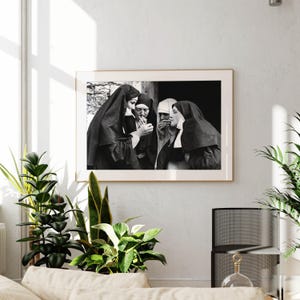 a black and white photo of a nun and a nun in a living room