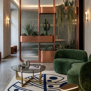 Alfombra moderna abstracta con diseño de hoja de monstera, tejida a mano – Decoración botánica premium en azul marino y crema con borlas.