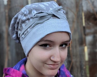 Plumes blanches et chapeau chirurgical gris réversible avec des boutons