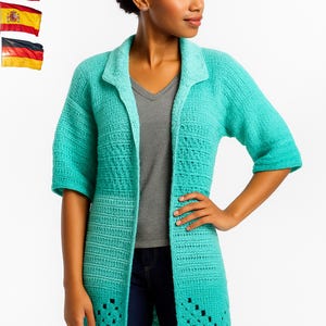May include: A long, turquoise crochet cardigan with short sleeves and a collared neckline. The cardigan features a textured stitch pattern and openwork detailing near the hem. The model is wearing a gray v-neck shirt and blue jeans.