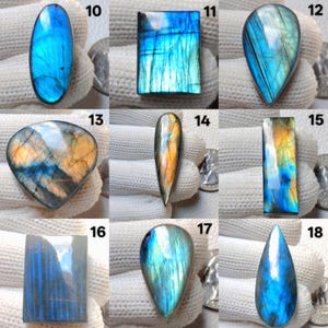 May include: A collection of polished labradorite gemstones in various shapes, including oval, rectangular, and teardrop. The stones display iridescent flashes of blue, green, and gold. Each stone is unique, showcasing natural patterns and colors.