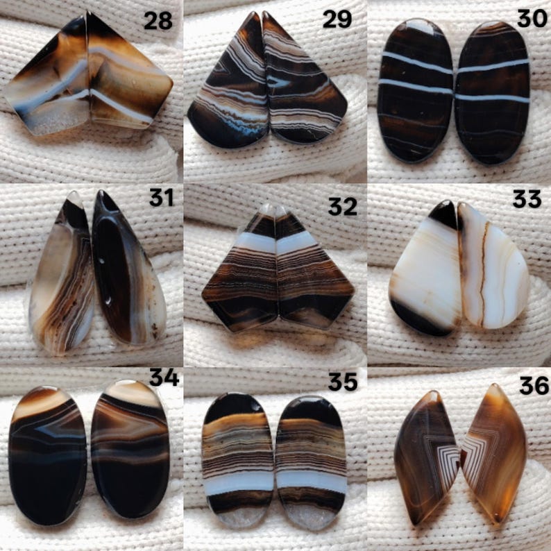 May include: A selection of polished agate stones in diverse shapes, such as teardrop, oval, and geometric forms. The stones display a blend of brown, white, and black banding patterns. Each pair is numbered for identification.