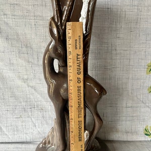 May include: A brown ceramic vase shaped like a deer with a textured surface. The vase is 12 inches tall.