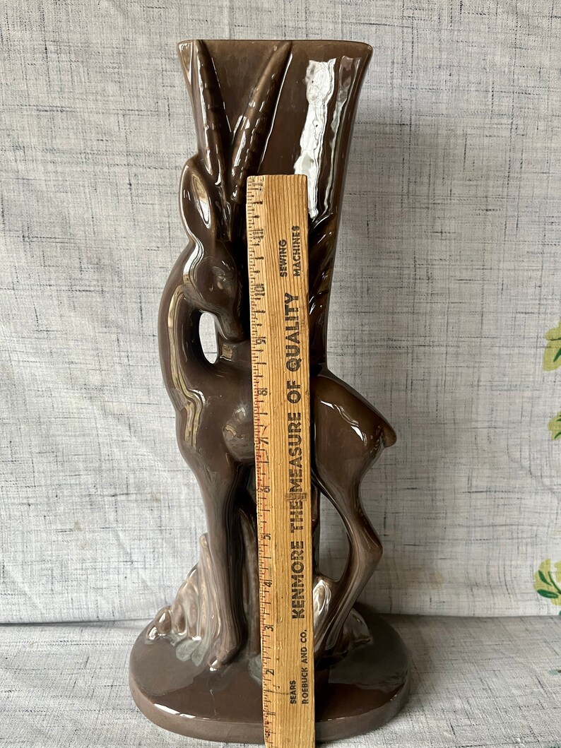 May include: A brown ceramic vase shaped like a deer with a textured surface. The vase is 12 inches tall.