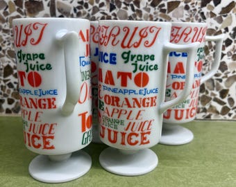 Set of four vintage ceramic juice mugs with fruit and vegetable graphics