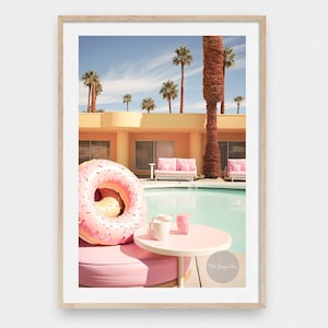 May include: A pink pool float shaped like a donut with pink frosting and sprinkles sits by a pool with a pink lounge chair and a small white table with two pink drinks. The text "Palm Springs Love" is visible in the bottom right corner of the image.