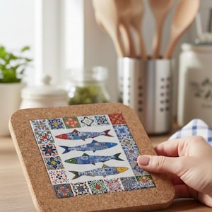May include: Square cork coaster with a decorative tile design featuring three fish in blue, red, and green. The coaster has a border of colorful geometric patterns and the word "PORTUGAL" is visible.
