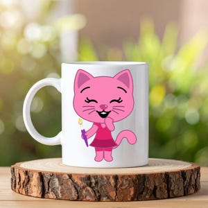 May include: A white ceramic mug featuring a cartoon illustration of a pink cat wearing a dark pink dress and holding a small paintbrush with a yellow tip. The cat has a smiling expression with closed eyes and a visible tail extending to the right.