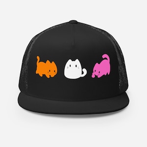 May include: Black trucker hat featuring three cartoon cats in orange, white, and pink. The cats are in a row, with the orange cat on the left, the white cat in the middle, and the pink cat on the right. The hat has a mesh back.