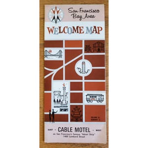 May include: A vintage San Francisco Bay Area Welcome Map. The map features illustrations of landmarks, including the Golden Gate Bridge and a cable car, set against a brown and white background. The text includes "WELCOME MAP" and "CABLE MOTEL".