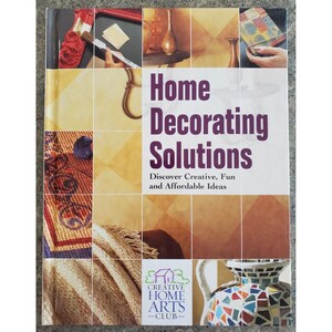 May include: A softcover book titled Home Decorating Solutions: Discover Creative, Fun and Affordable Ideas. The cover features a grid of various home decor projects, including painting, mosaic work, and fabric textures, with the Creative Home Arts Club logo.