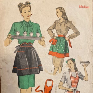 May include: Vintage Du Barry Patterns 15¢ sewing pattern. The illustration shows women in aprons, including a black apron with orange trim, a red apron, and a green polka-dot apron. The word "Medium" is visible.