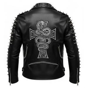Op de afbeelding: Zwarte leren jas met zilveren spikes op de schouders en mouwen. De achterkant heeft een wit geborduurd kruis met een slangenontwerp. Zilveren kettingen en ritsen maken de edgy look compleet.