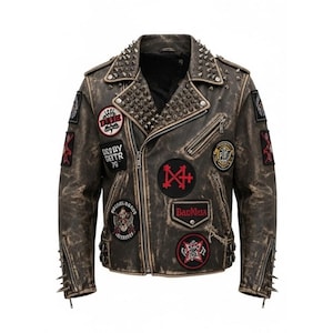 Op de afbeelding: Verweerde bruine leren jas met meerdere patches en zilveren studs. De jas heeft een ritssluiting, meerdere zakken en decoratieve patches met tekst en afbeeldingen. De kraag en schouders zijn versierd met zilveren studs.