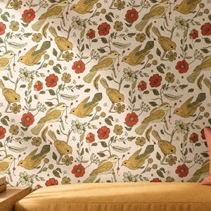 May include: Wallpaper featuring a repeating pattern of yellow birds, red flowers, and green foliage on a cream background. The design includes small feathers and berries interspersed among the birds and floral elements, creating a dense botanical scene.