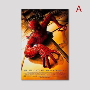 May include: A movie poster featuring Spider-Man in a red and blue suit, clinging to a reflective surface. The poster has a warm, golden background with the title "SPIDER-MAN" at the bottom. The letter "A" is in the top right corner.