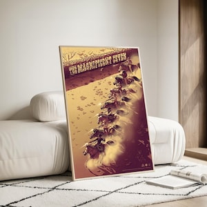 Puede incluir: Un póster enmarcado con una ilustración estilizada de siete jinetes a caballo, corriendo por un paisaje desértico. El título "THE MAGNIFICENT SEVEN" se muestra en la parte superior. La paleta de colores incluye tonos marrones, beige y morados.