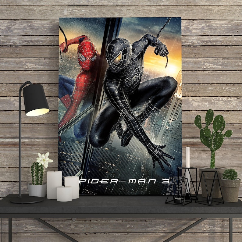 May include: A framed movie poster for Spider-Man 3. The poster features two versions of Spider-Man: one in a red and blue suit and the other in a black suit. The background shows a cityscape with a sunset.
