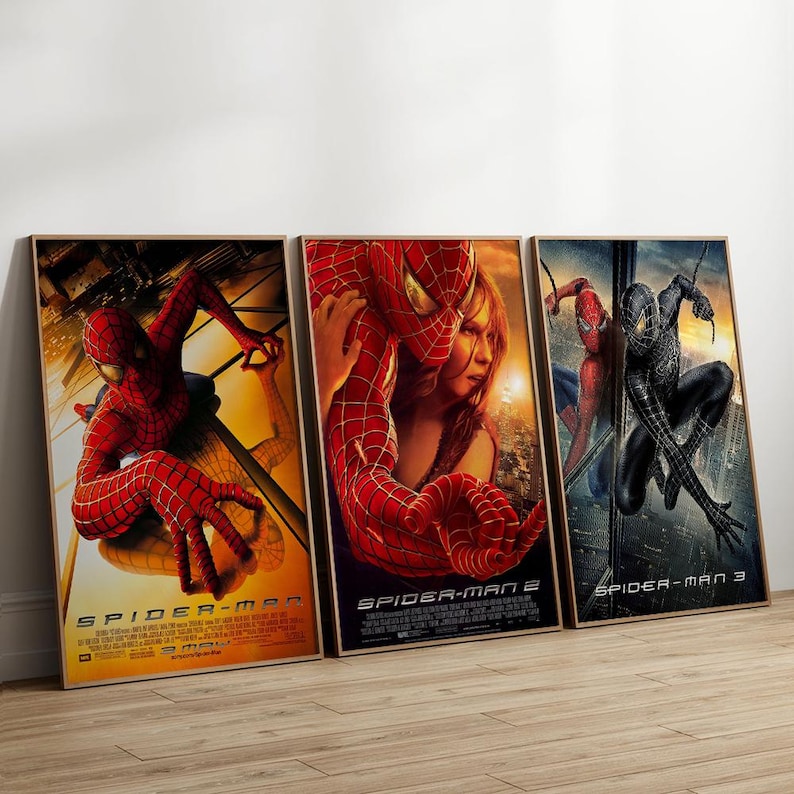 May include: Three framed movie posters featuring Spider-Man. The posters showcase action scenes with the superhero in his iconic red and blue suit, and a black suit. The titles "Spider-Man", "Spider-Man 2", and "Spider-Man 3" are visible.
