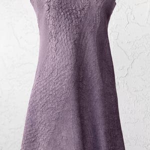 May include: A sleeveless, A-line dress in a deep purple color. The dress has a textured, crinkled fabric and a scoop neckline.