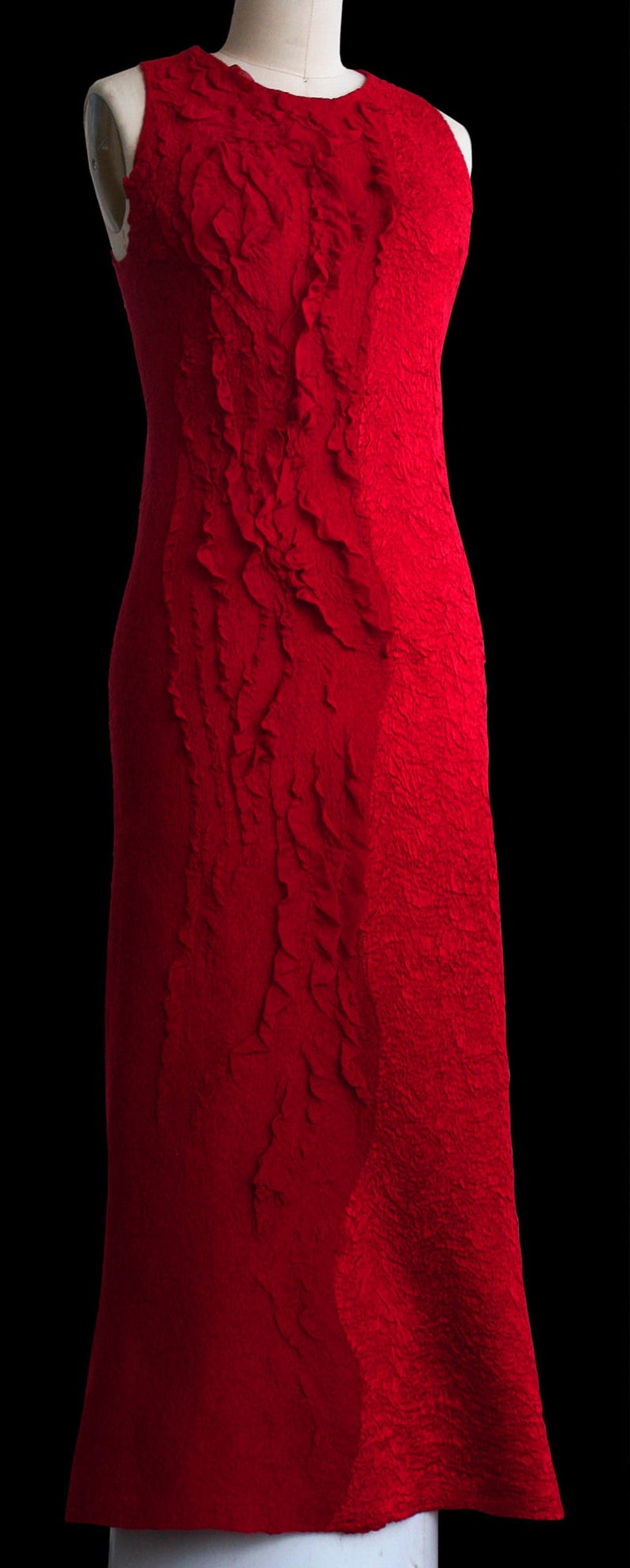May include: A sleeveless red dress with a textured, crinkled fabric. The dress has a fitted silhouette and a slightly flared skirt.