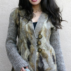 May include: A woman wearing a long-sleeved, button-down jacket with a unique pattern in shades of brown, gray, and gold. The jacket has large, round buttons and is paired with gray pants. She is also wearing sunglasses.