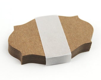 May include: A stack of brown paper gift tags with scalloped edges, wrapped in white tape.