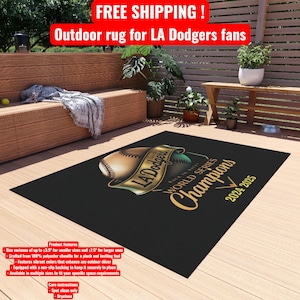 May include: Black outdoor rug featuring the LA Dodgers logo and "World Series Champions 2024-2025" text. The rug has a baseball graphic and is designed for outdoor use. Made from polyester chenille with a non-slip backing.