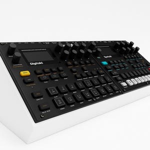 Op de afbeelding: Zwart-wit elektronisch muziekproductieapparaat met knoppen, toetsen en een scherm. Het apparaat is voorzien van de tekst "Digitakt". De basis is wit en de bovenkant is zwart. Het heeft een verscheidenheid aan gekleurde knoppen.