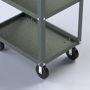 May include: A gray metal utility cart featuring a multi-tiered design with open shelves, vertical support beams, and four black swivel casters attached to the base with silver hardware. The frame has a textured finish and visible bolt connections.