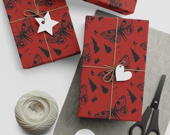 May include: Several wrapped gifts with red paper featuring a black butterfly and tree pattern. Each package is tied with twine and a white tag. A ball of twine, scissors, and blank tags are also visible.