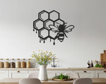 May include: Black metal wall art featuring a honeycomb design with a bee. The honeycomb has dripping honey details. The bee has detailed wings and body. This decorative piece is suitable for kitchen or dining room decor.