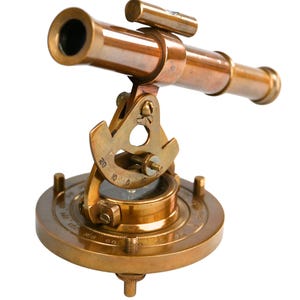 May include: A vintage brass telescope with a detailed design. The telescope is mounted on a circular base with a graduated scale. The brass has a warm, antique finish, and the instrument appears to be fully functional.