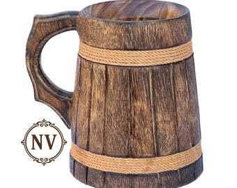 May include: A wooden beer mug with a dark brown finish, featuring a decorative handle and a rope accent around the middle. The mug has a rustic, barrel-like design, perfect for serving beverages. The mug is made of wood.