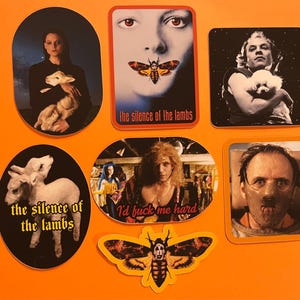 May include: A selection of stickers with imagery from the film "The Silence of the Lambs." The stickers feature characters, a moth, and text from the movie. The stickers are displayed on an orange background.