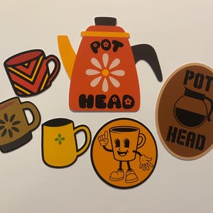 May include: A collection of coffee-themed stickers featuring a retro design. Includes an orange coffee pot with the text "POT HEAD", various coffee mugs, and an oval sticker with a coffee pot illustration and the text "POT HEAD".