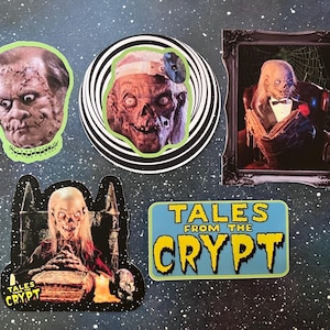 May include: A collection of five Tales from the Crypt stickers. One sticker shows a stitched face, another a zombie with a headlamp on a spiral background, a framed portrait of a skeleton in a tuxedo, a skeleton reading a book, and a logo sticker.