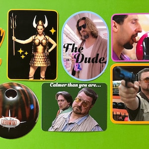 May include: A selection of stickers featuring characters and imagery from the film "The Big Lebowski." Includes a bowling ball, a sticker with the text "The Dude," and other character images. The stickers are on a green background.